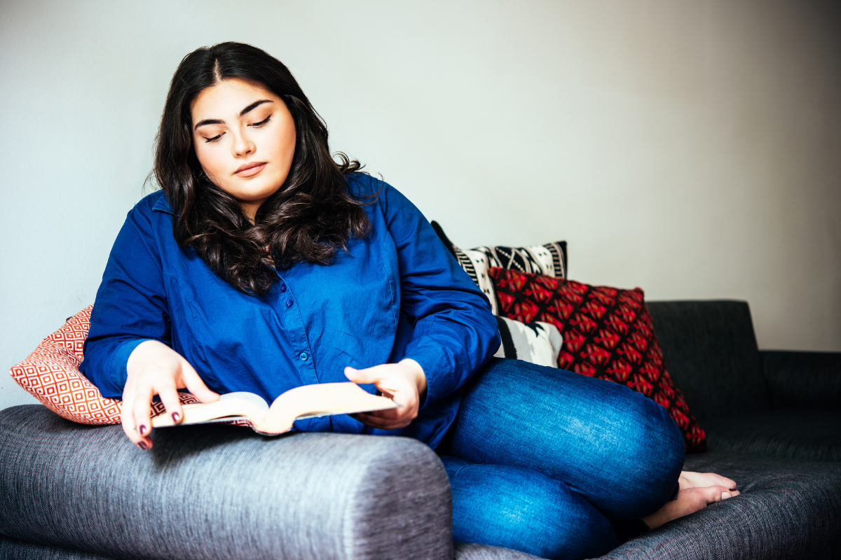 Woman sitting on a couch reading.