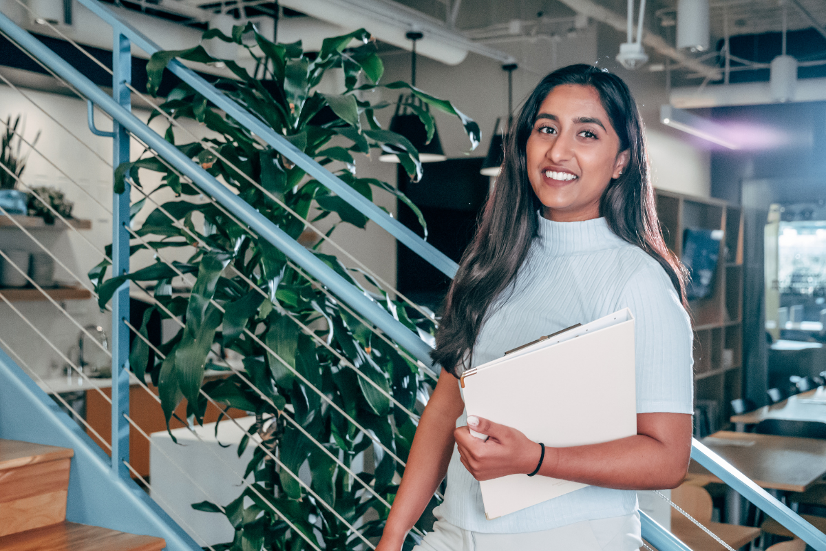 Professional woman holding a notebook.