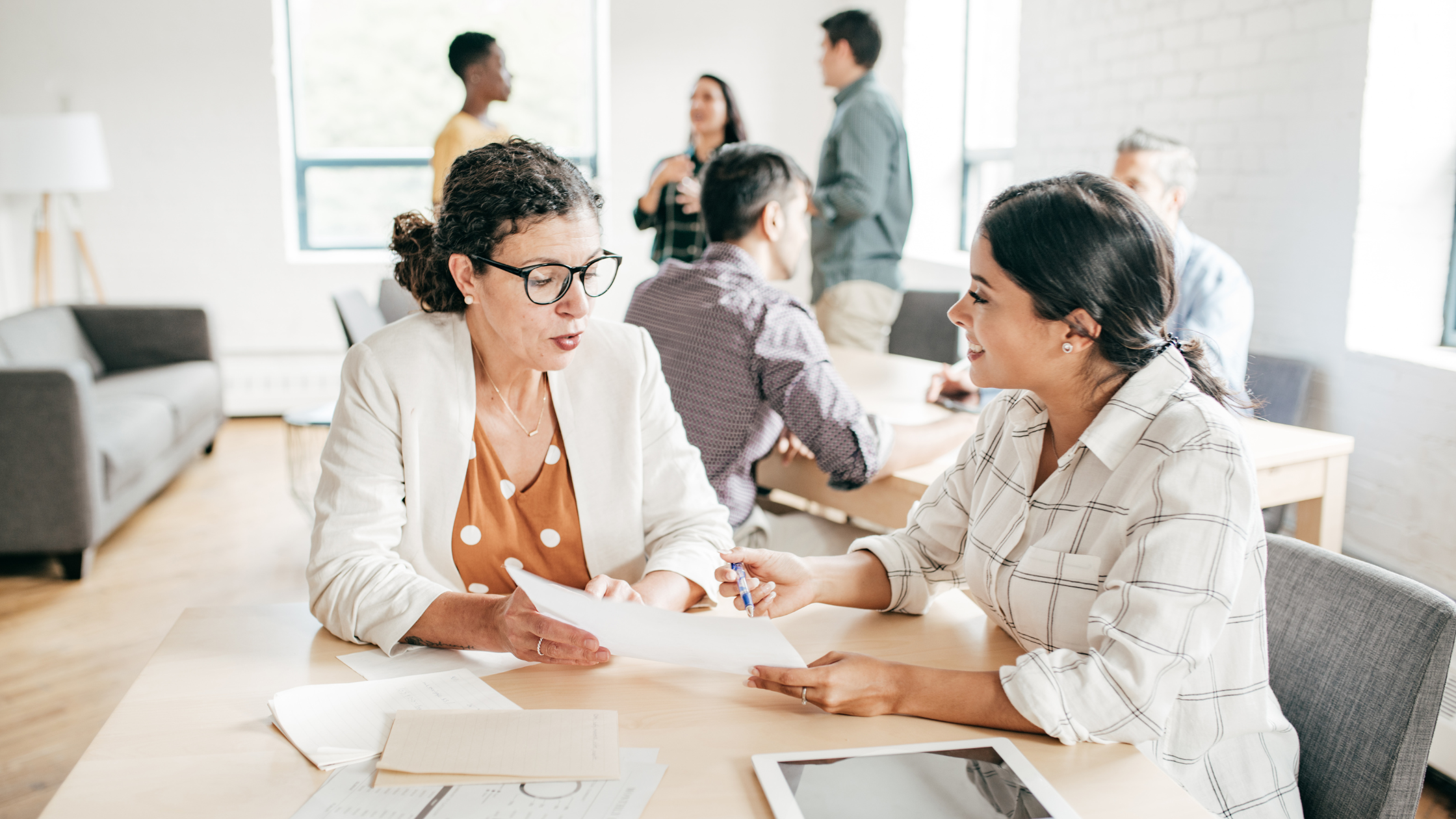 Woman discussing at a table | Business Appraisal vs Business Valuation