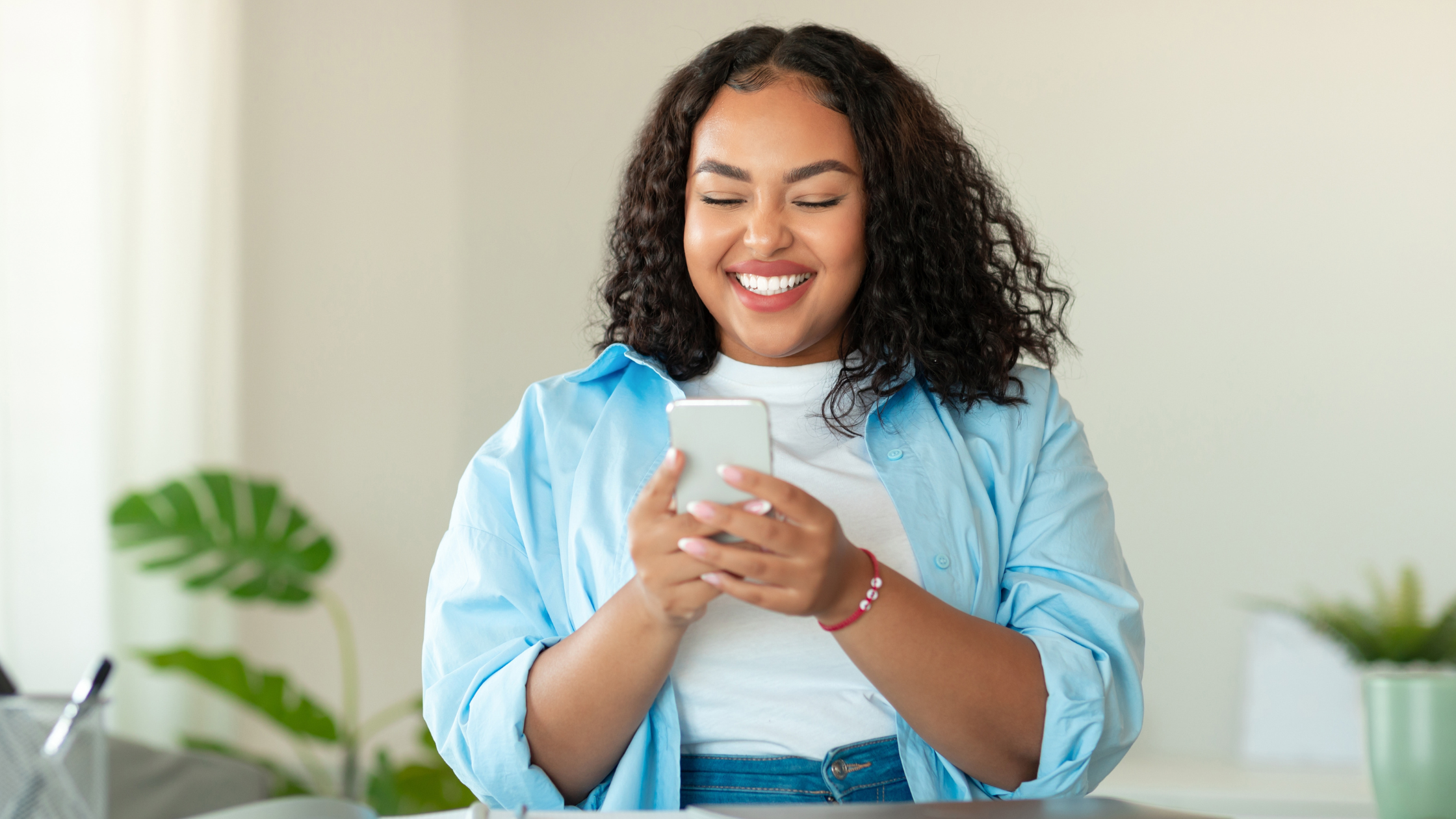 How to Sell Your Small Business with Confidence | Woman holding her phone smiling 