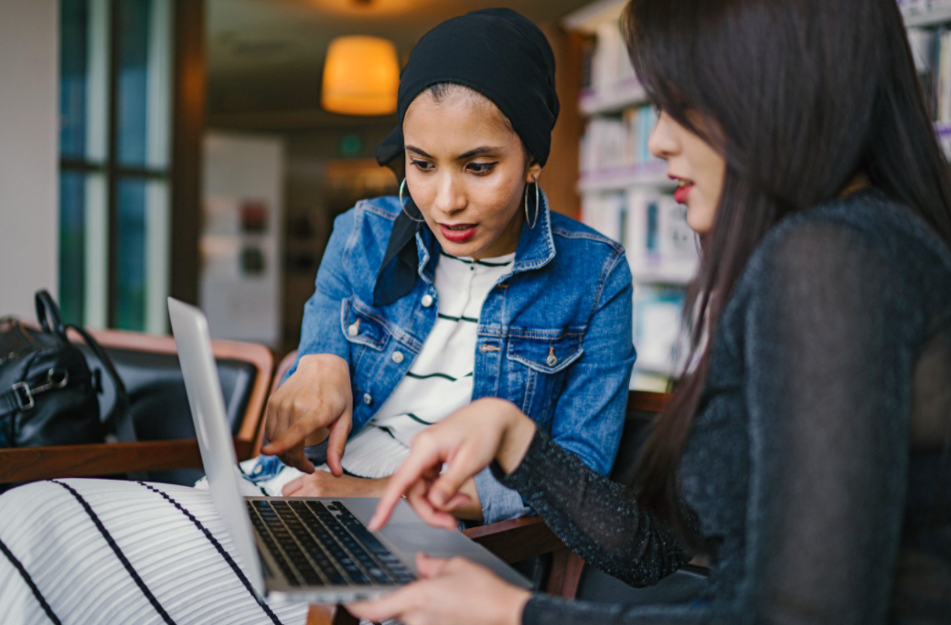 Two women working on a laptop.