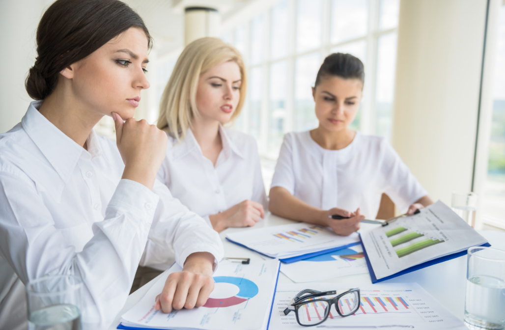 Three women looking at graphs.