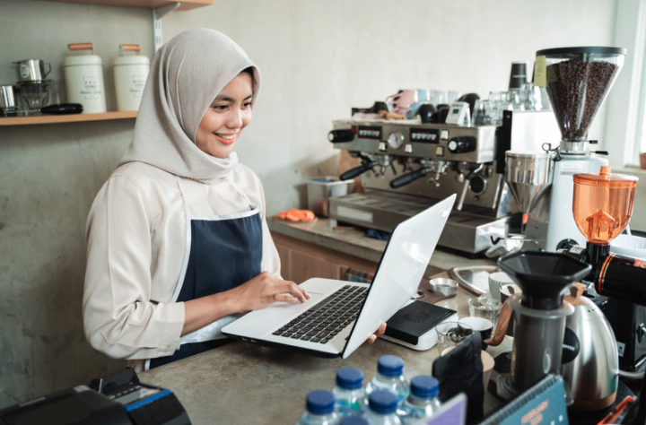 Woman working on a laptop at a coffee shop. 