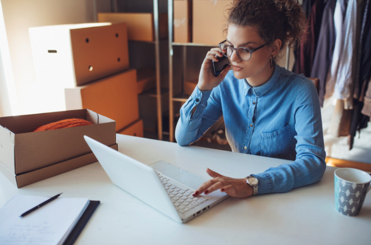 Woman on the phone working on laptop.