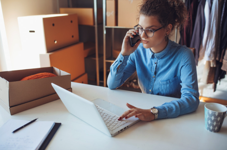 Woman on the phone working on laptop. 