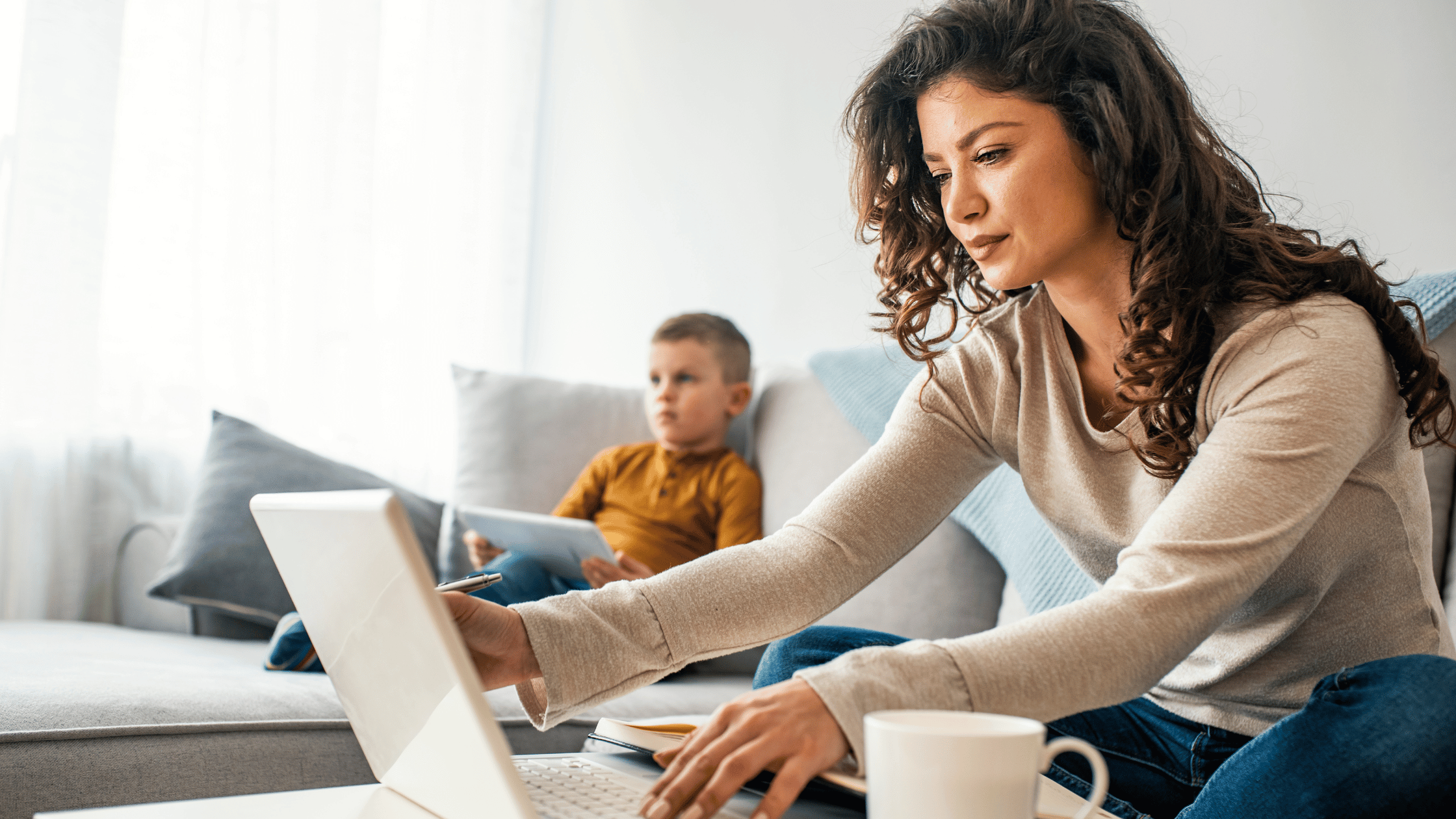 Woman working at laptop with child in the background | What is a money market account