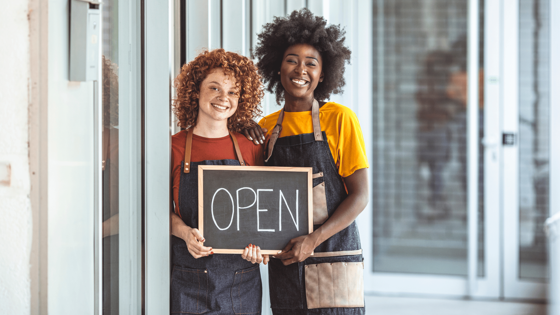 Guide to Starting a New Business | Two women business owner holding an open sign 