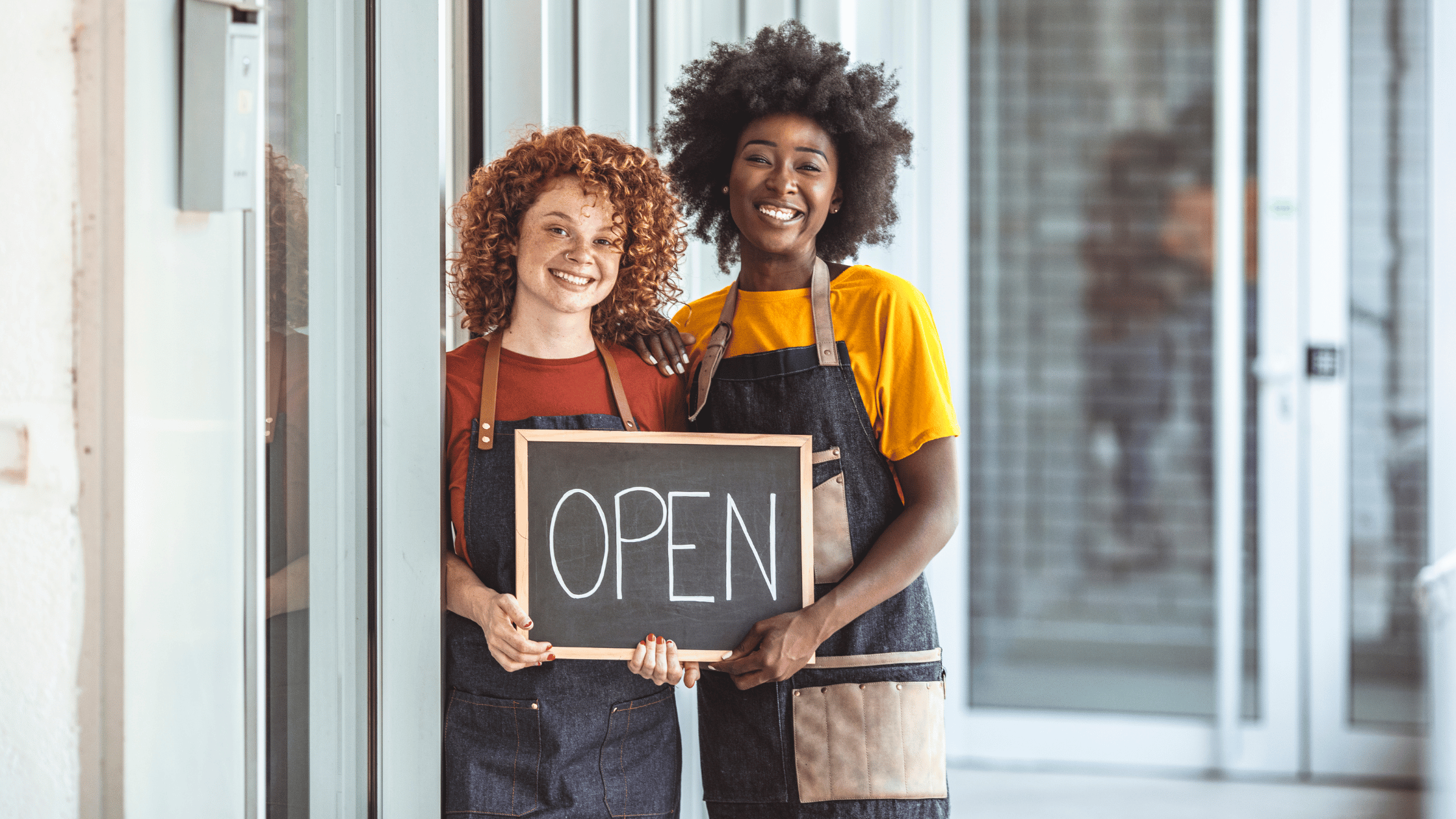 Guide to Starting a New Business | Two women business owner holding an open sign