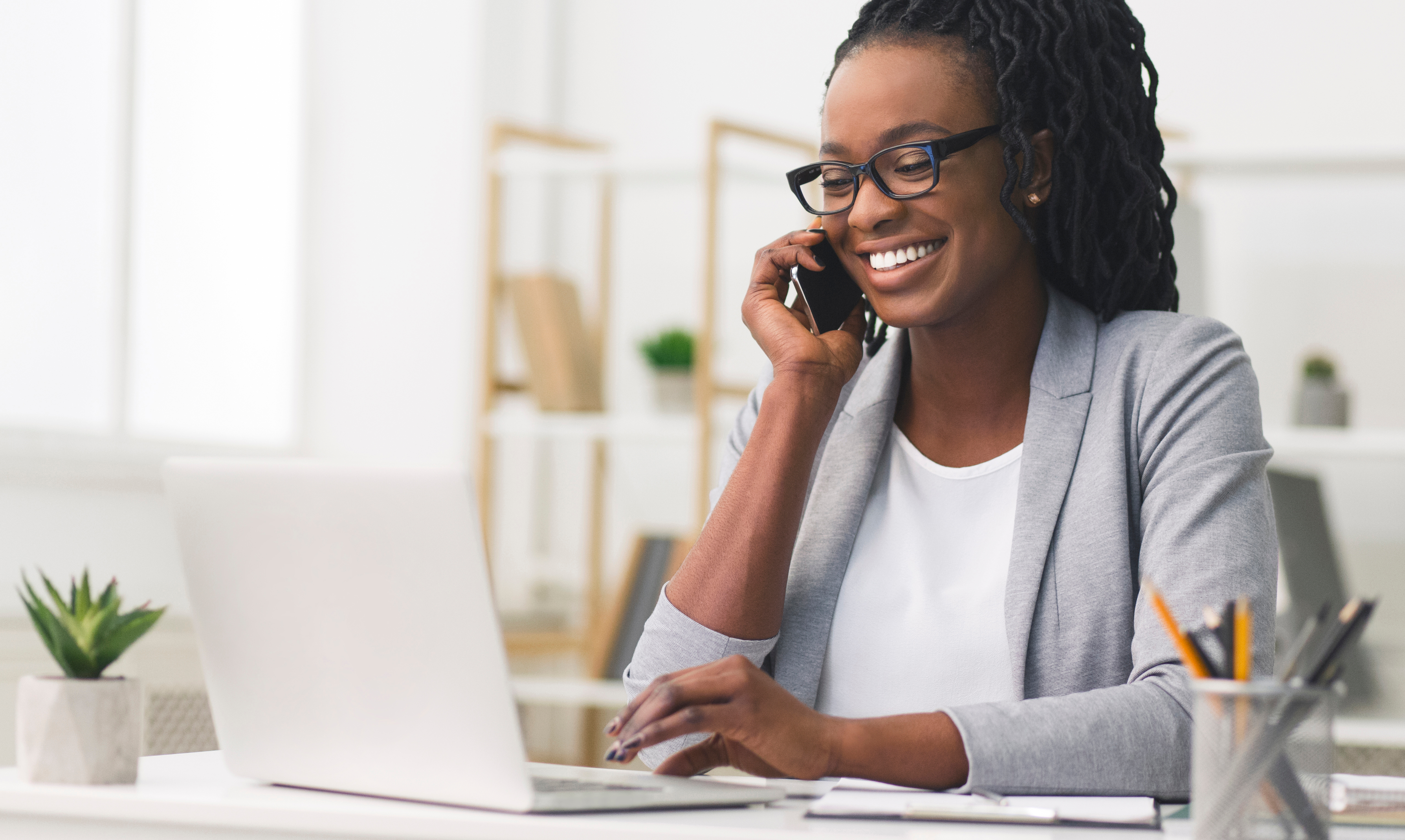 Woman on the phone working on a laptop. 